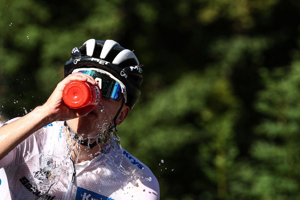UAE Team Emirates' Slovenian rider Tadej Pogacar wearing the best young rider's white jersey douses himself with water to cool down as he cycles in the final ascent of Saint-Gervais-les-Bains in the last kilometers of the 15th stage of the 110th edition of the Tour de France cycling race, 179 km between Les Gets Les Portes du Soleil and Saint-Gervais Mont-Blanc, in the French Alps, on July 16, 2023.