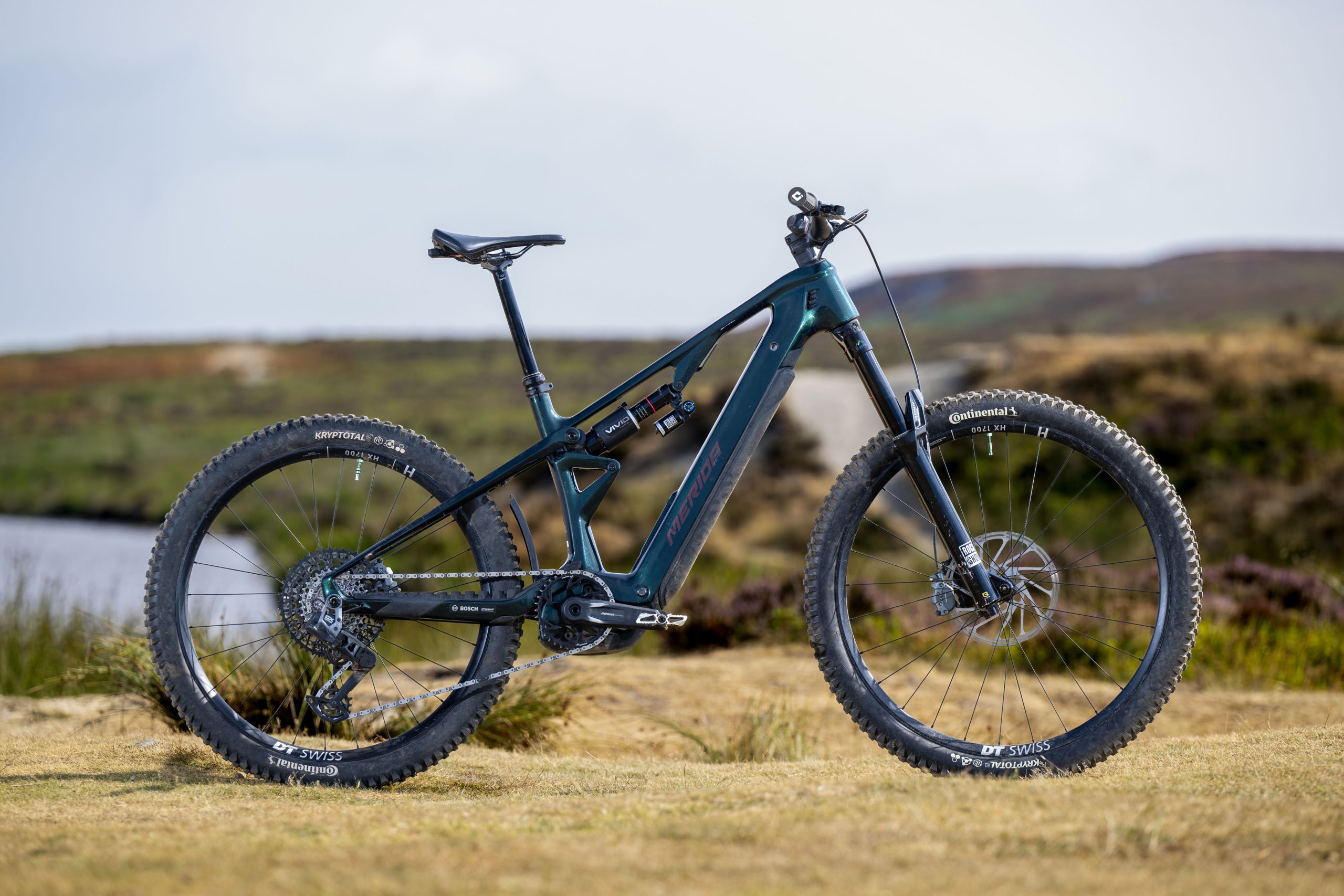 Dark green Merida Lithos 8000 electric mountain bike shown in side profile with mixed wheels and RockShox suspension