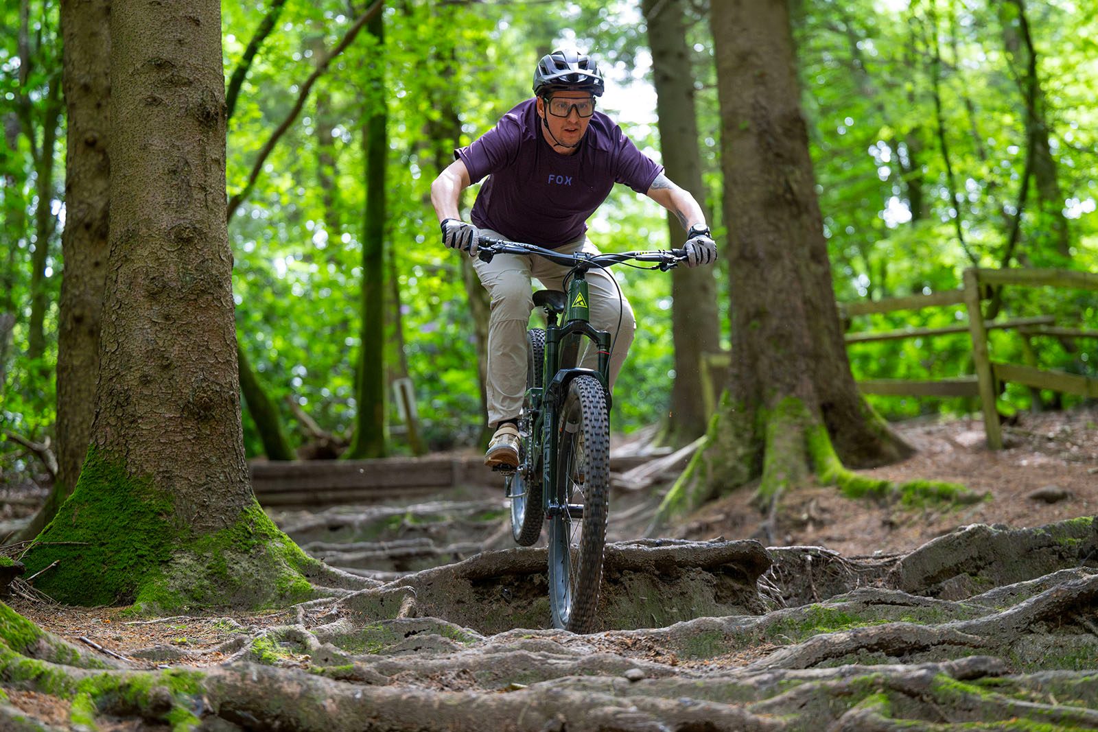 Male rider in purple top riding the Forbidden Druid V2 MX full suspension mountain bike