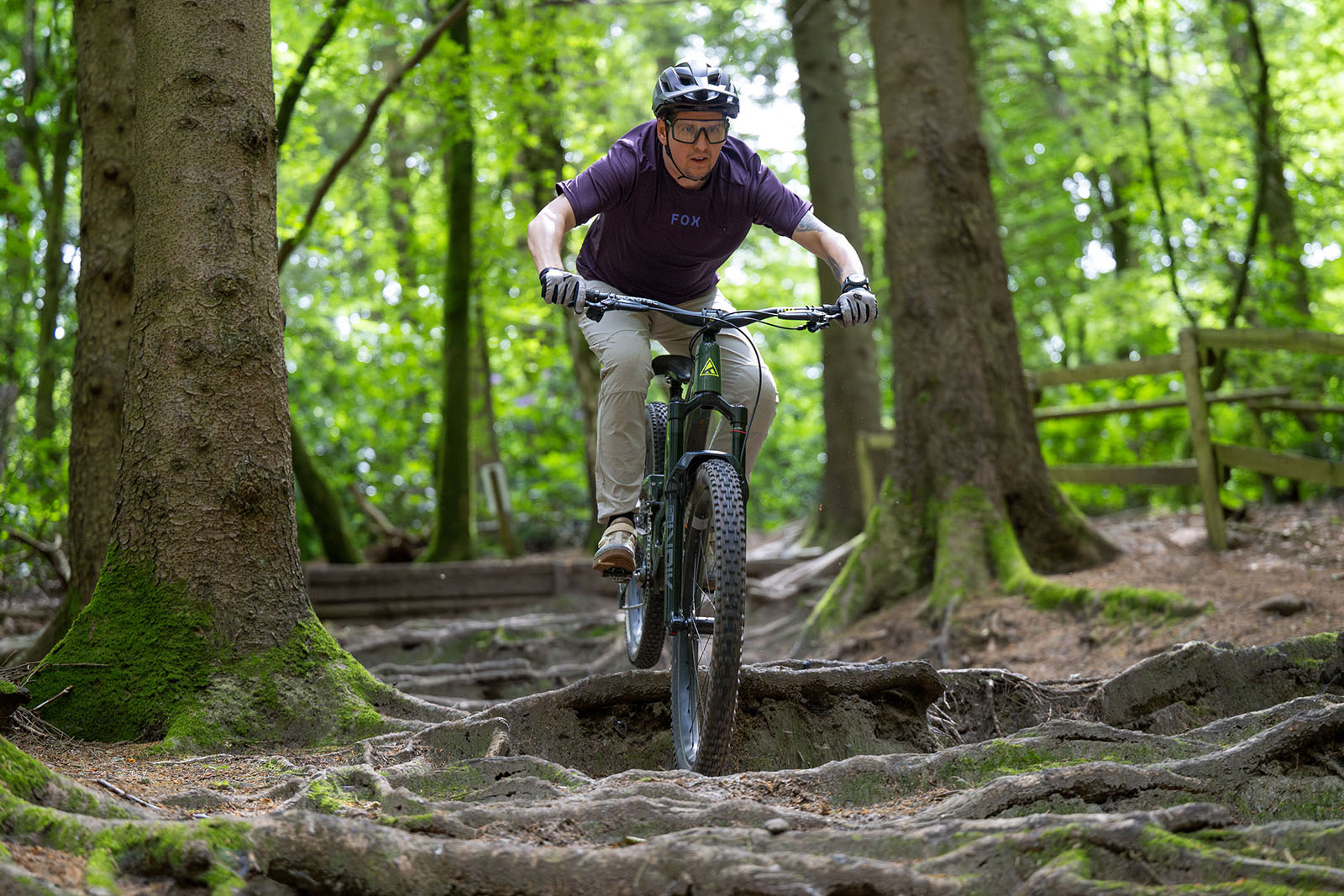 Male rider in purple top riding the Forbidden Druid V2 MX full suspension mountain bike