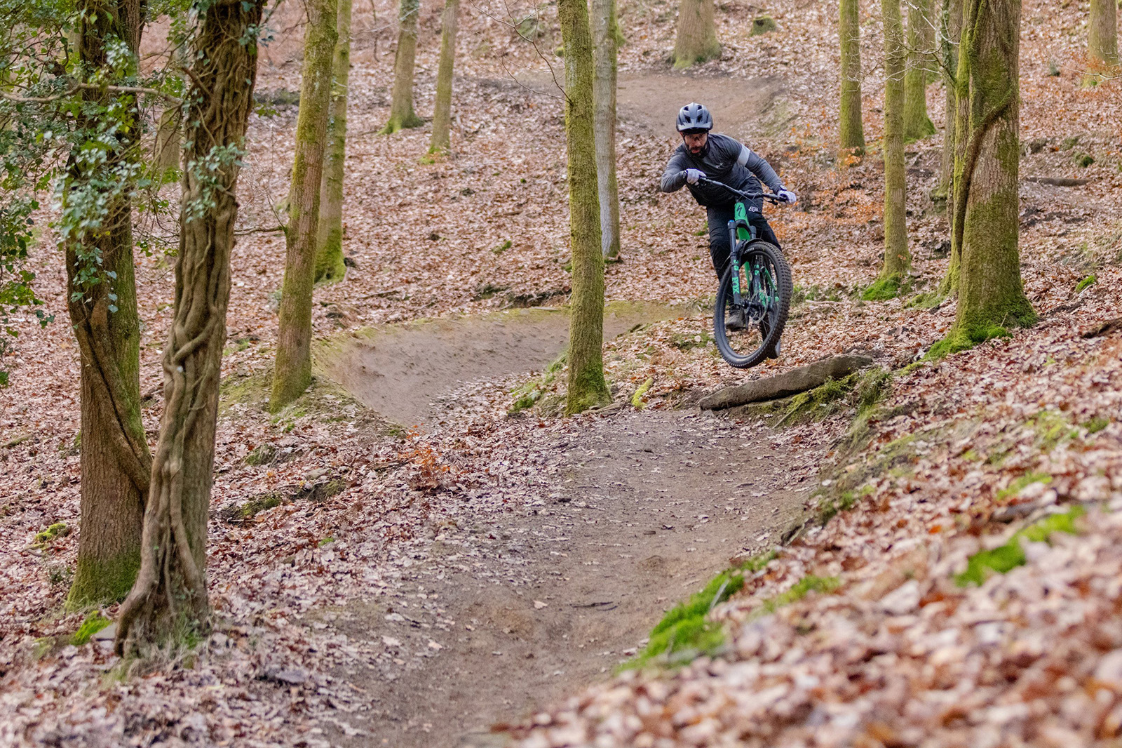 Male rider in grey top riding the Specialized Stumpjumper 15 Expert full suspension mountain bike