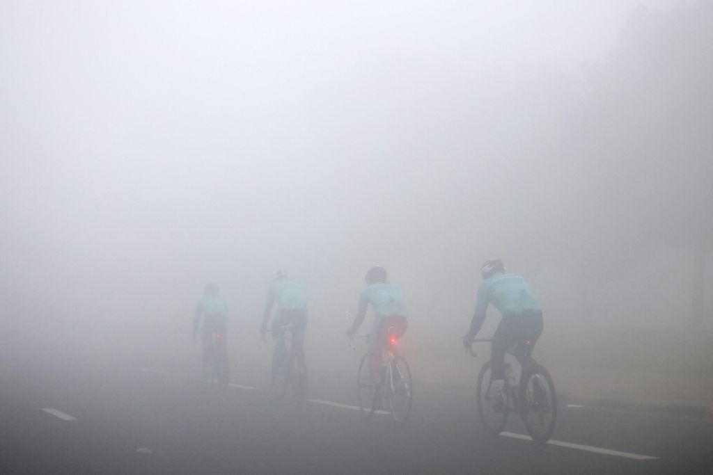 KUWAIT-WEATHER-FOG Cyclists ride along a street through dense fog in Kuwait City on January 27, 2023.